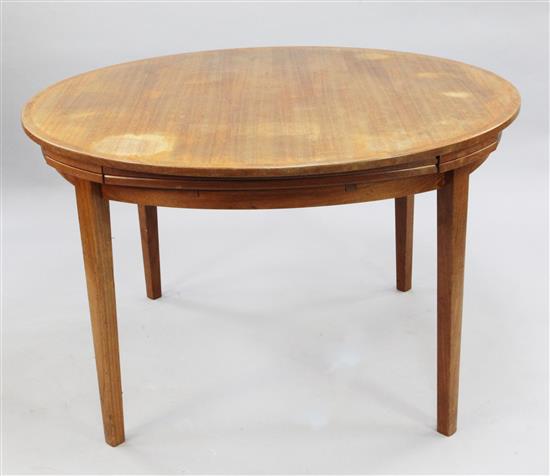 A Danish Dyrlund teak circular extending dining table, extends to W.5ft 9in.